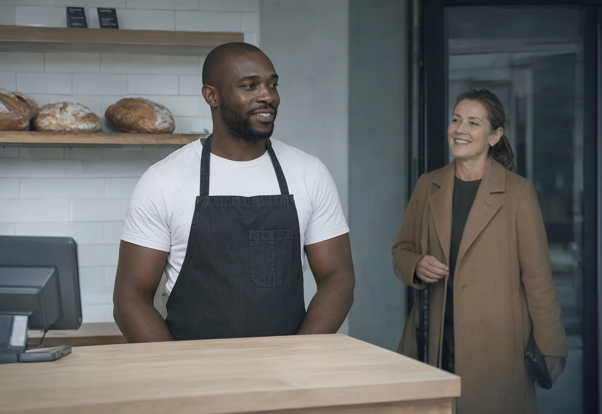 A bakery owner greeting a customer at the door